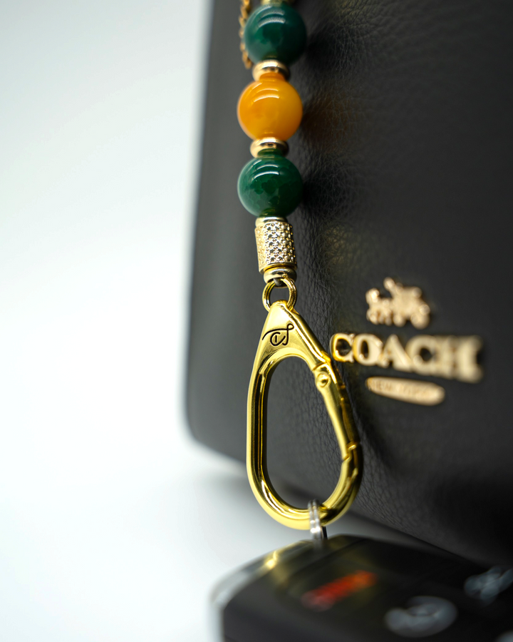 LD Keyfinder Golden Harvest-Mini featuring green and orange agate beads with a gold-plated sunflower charm on a bag.