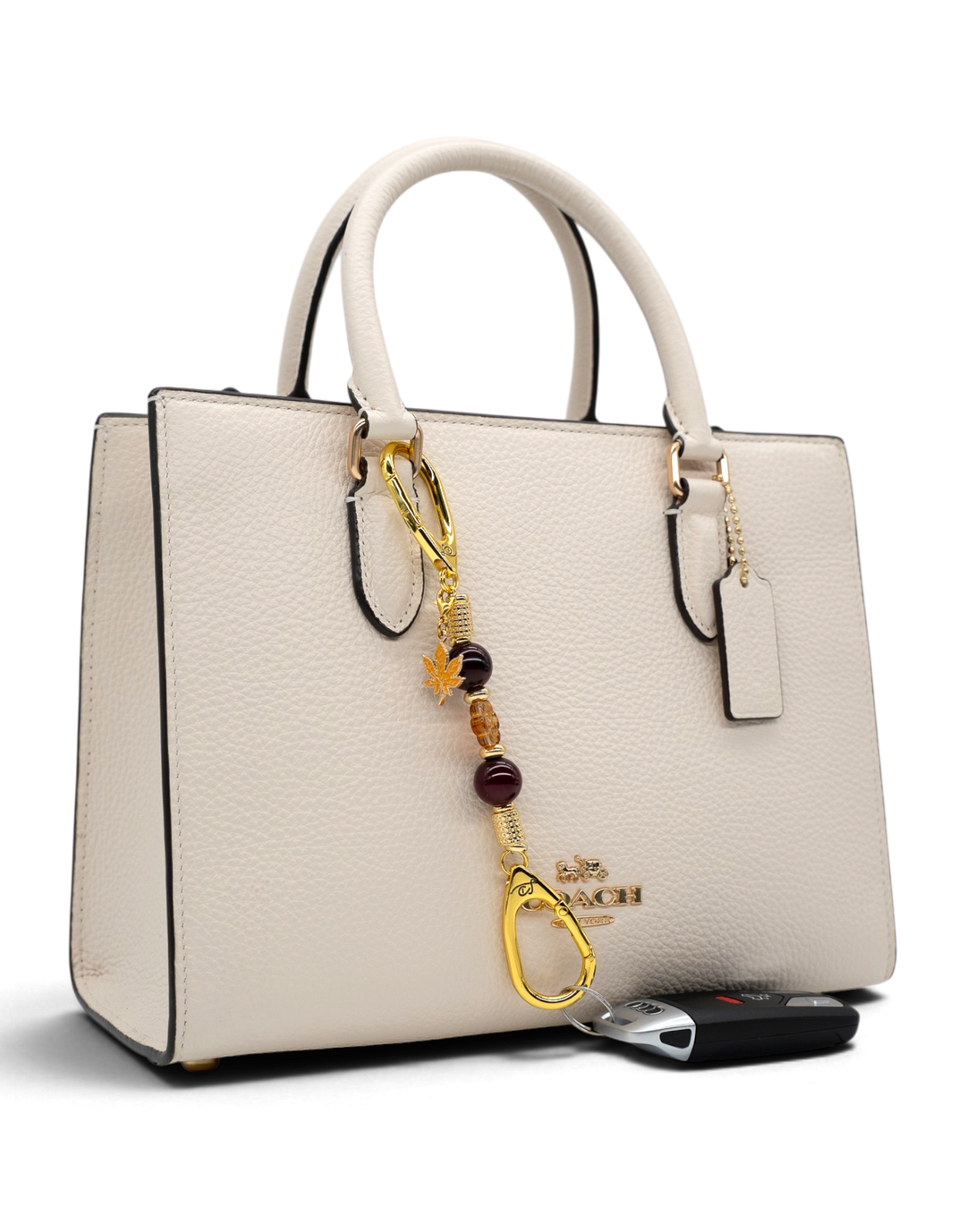 LD Keyfinder Hello Autumn-Mini charm with burgundy agate and glass flower bead attached to a cream leather handbag