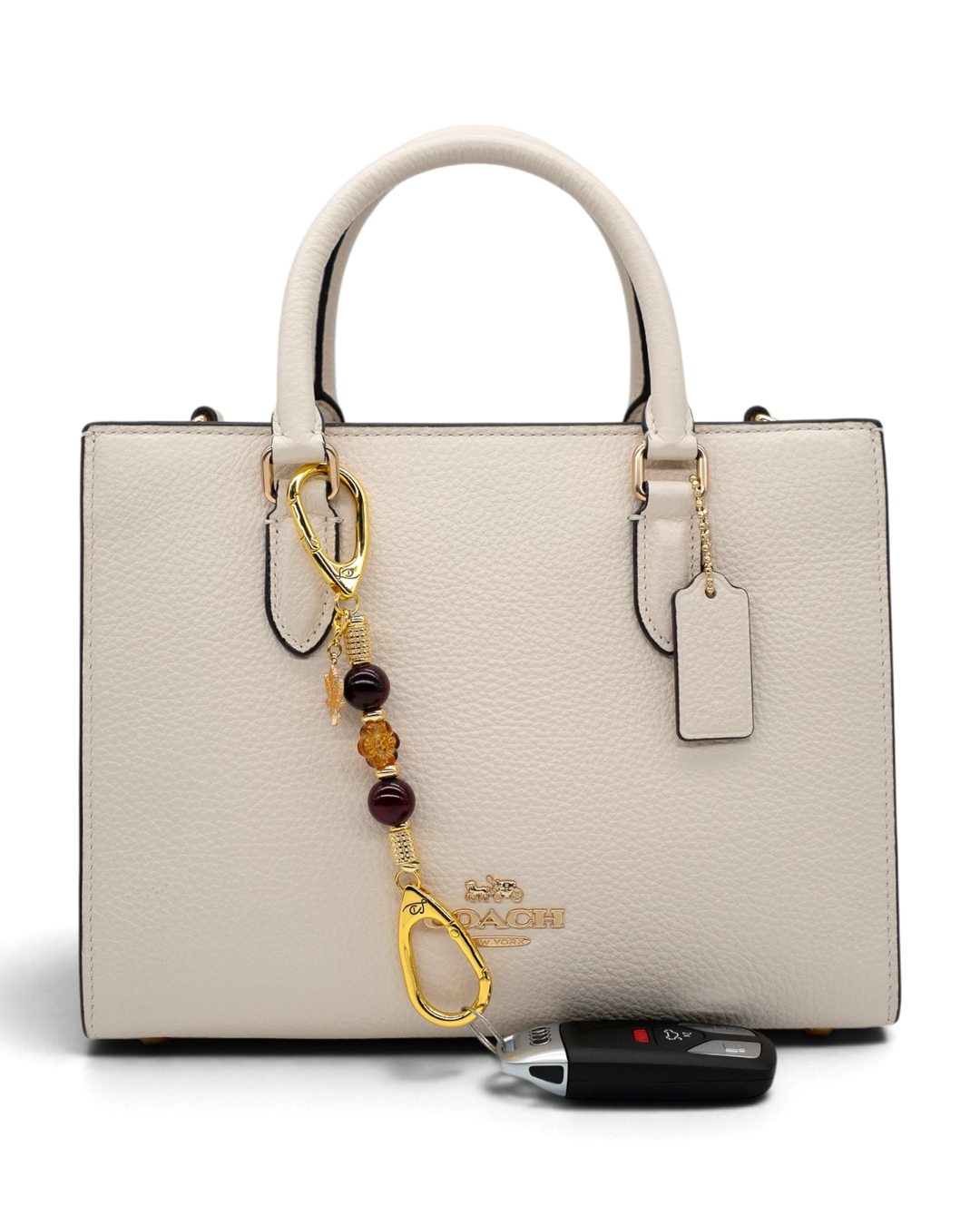 LD Keyfinder Hello Autumn-Mini beaded keychain with burgundy agate and glass flower charm attached to a cream handbag