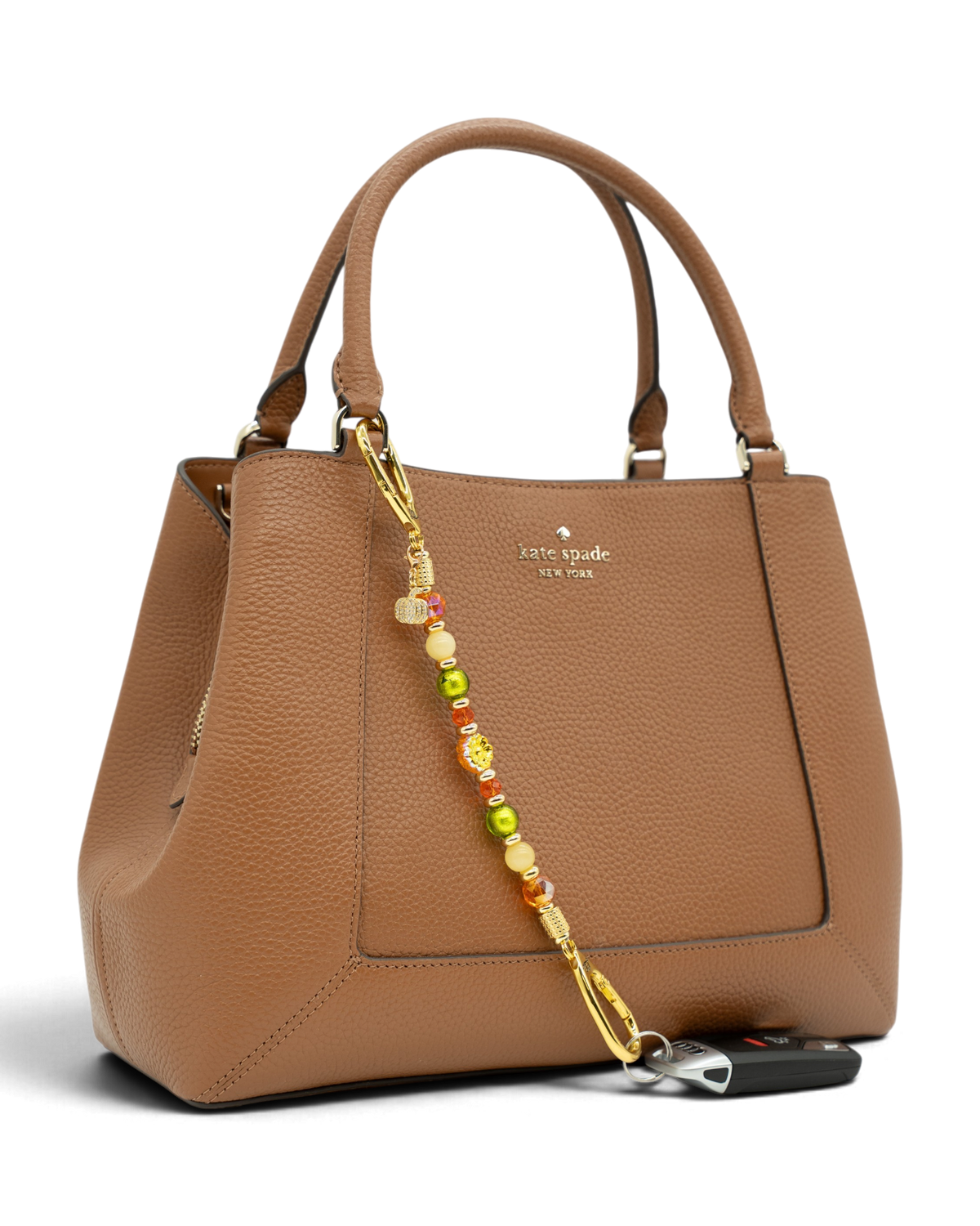 LD Keyfinder Autumn Festival beaded accessory with flower and pumpkin charms attached to a brown leather handbag
