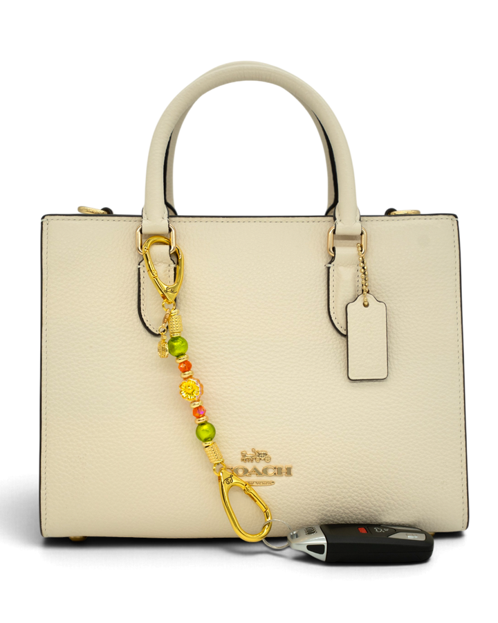 LD Keyfinder Autumn Festival-Mini featuring green foil and orange faceted beads with a gold pumpkin charm on a handbag