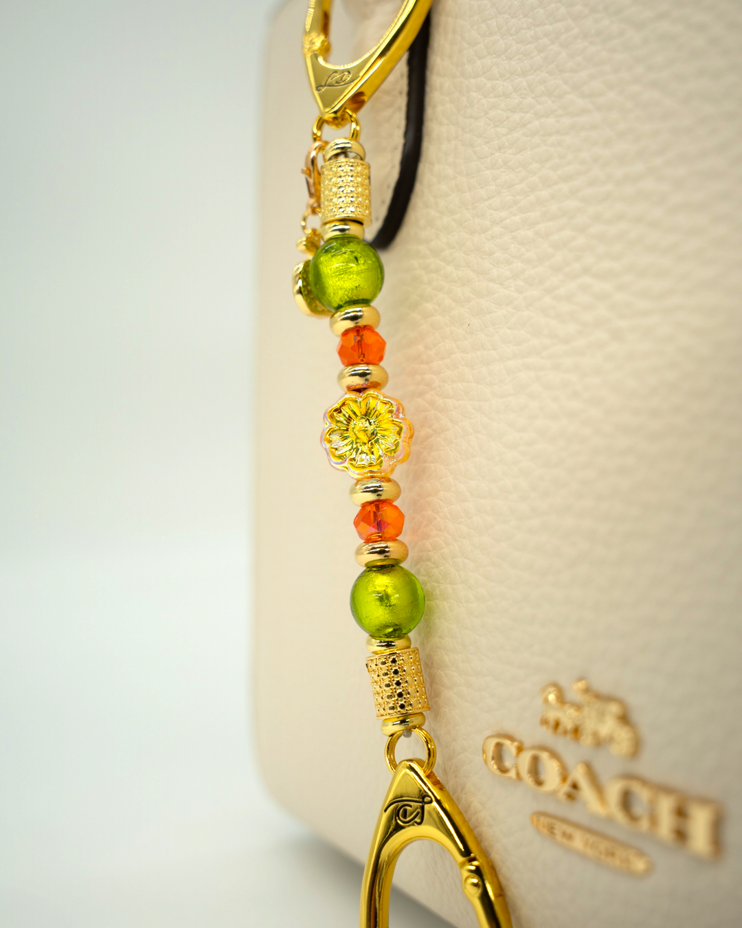 LD Keyfinder Autumn Festival-Mini featuring green foil beads, orange glass beads, gold spacers, and a flower charm.