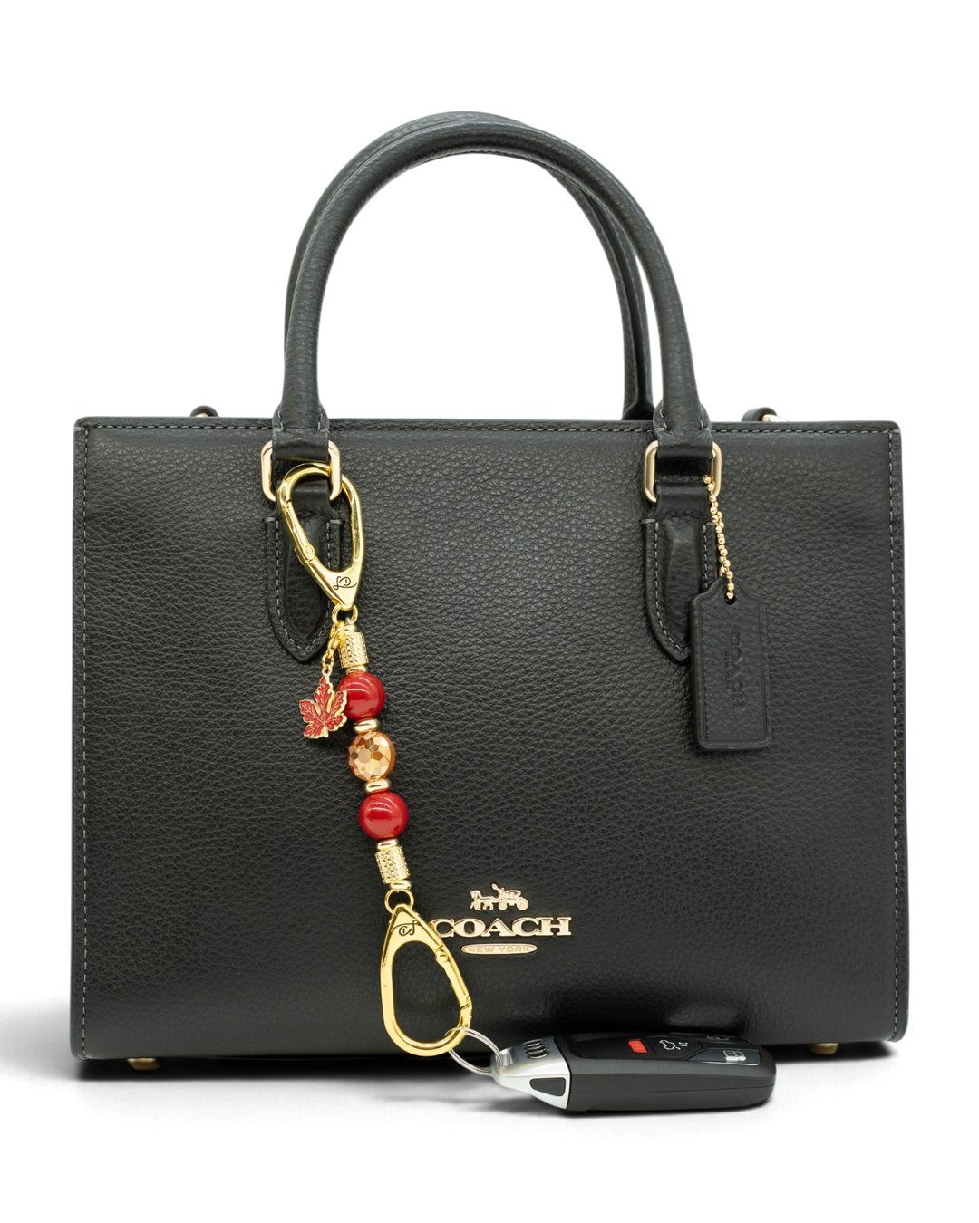 LD Keyfinder Autumn Glow-Mini beaded charm with red shell pearls and maple leaf attached to a black leather handbag