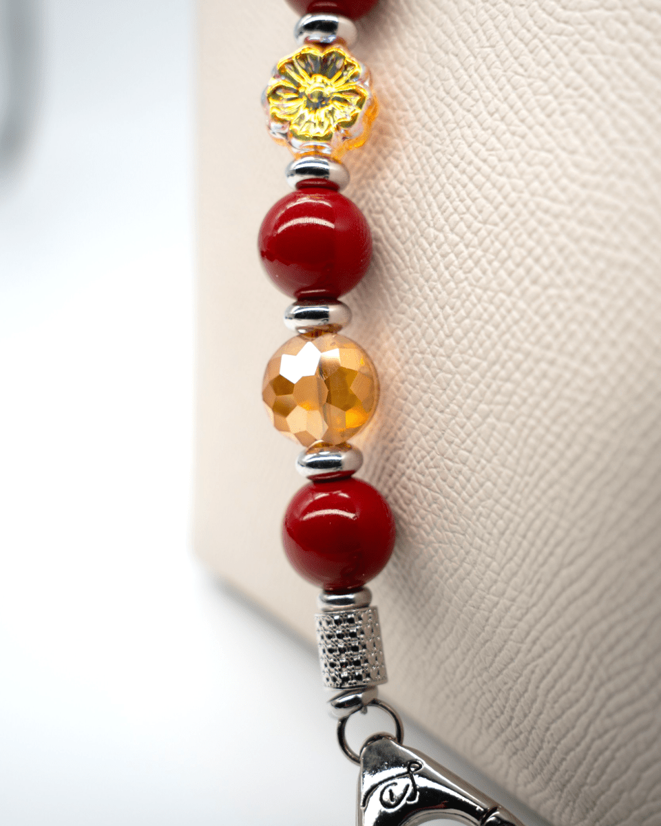 LD Keyfinder Autumn Whispers beaded keychain with red shell pearls, orange glass flower, and platinum-plated accents.