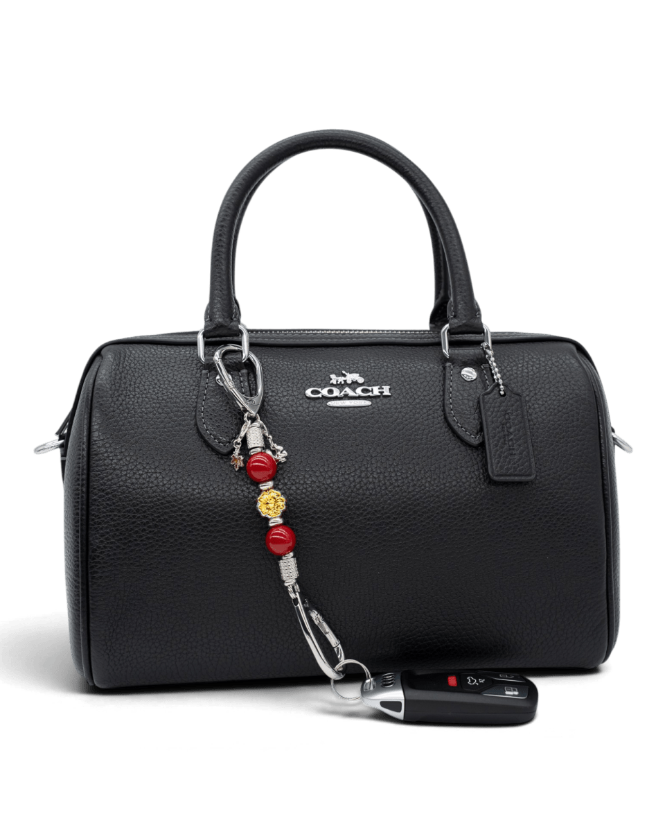 LD Keyfinder Autumn Whispers Mini accessory with red shell pearls and orange glass flower attached to a black handbag