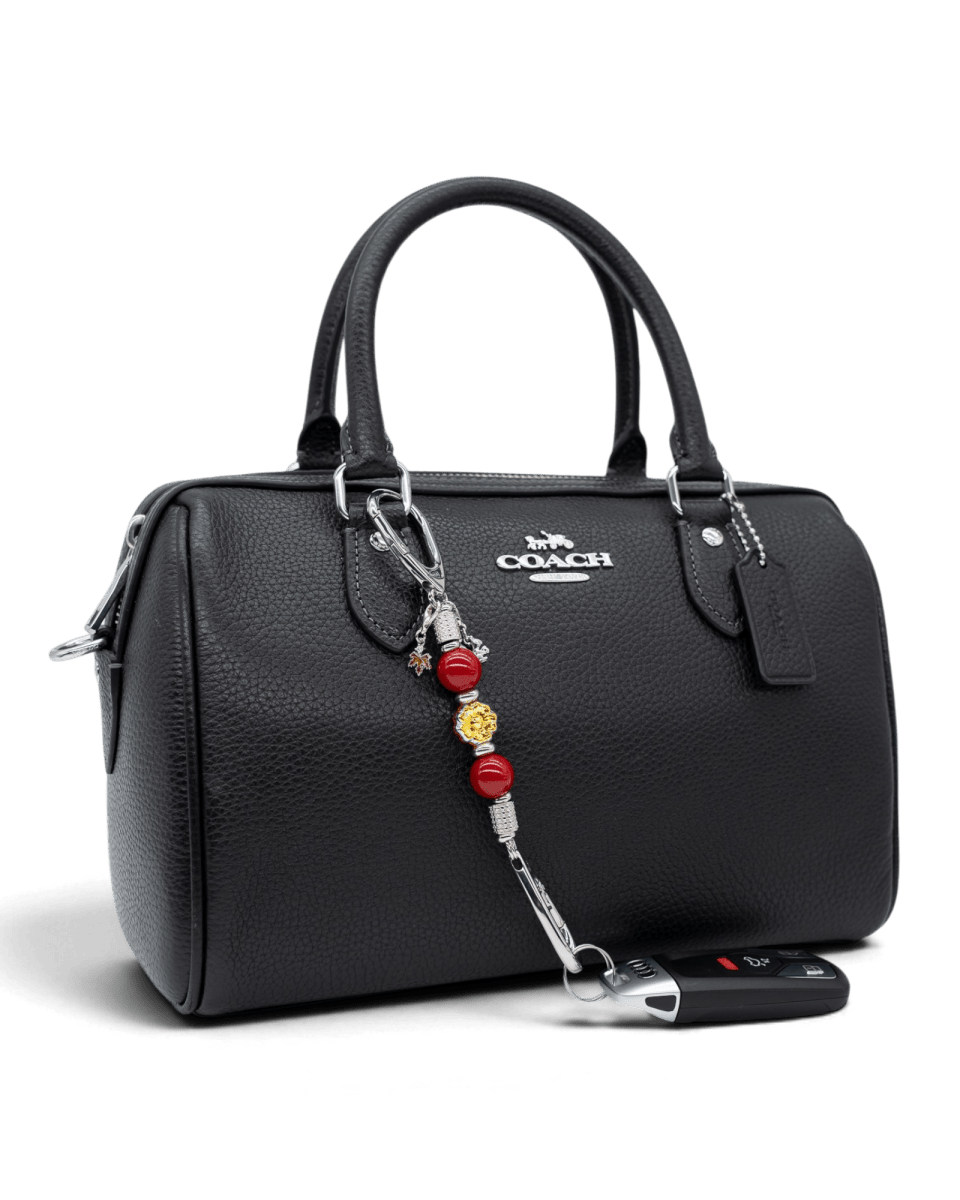 LD Keyfinder Autumn Whispers Mini accessory with red shell pearls and orange glass flower attached to a black handbag