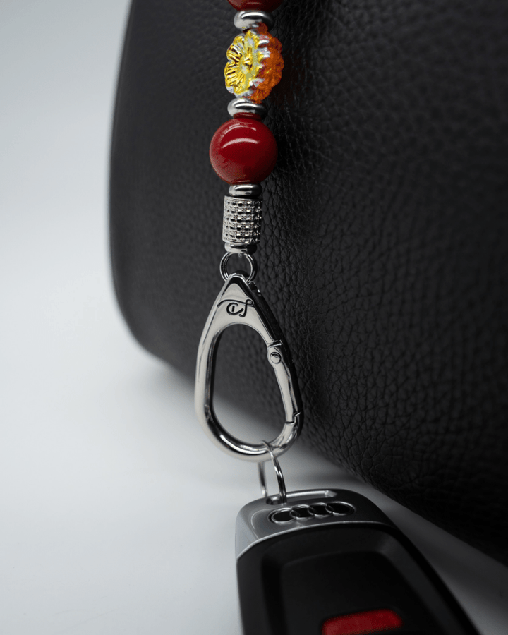 LD Keyfinder Autumn Whispers Mini featuring red shell pearls, an orange glass flower, and platinum-plated hardware.