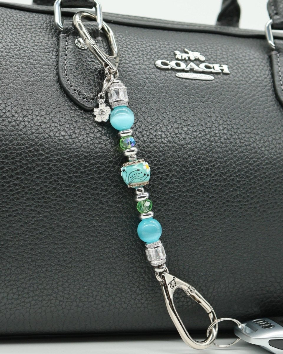 LD Keyfinder Petite Azure Meadow keychain with aqua blue cat's eye beads, green glass beads, and a lampwork daisy bead.