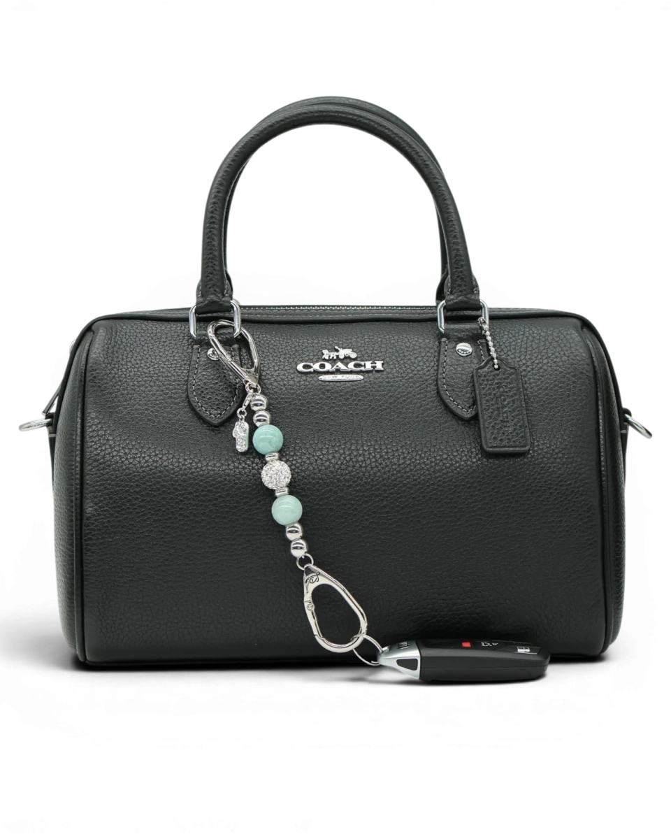 LD Keyfinder Beachside Bliss Mini beaded charm with aqua jade and crystal, attached to a black leather handbag.