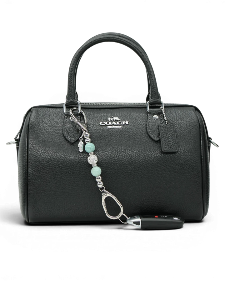 LD Keyfinder Beachside Bliss Mini beaded charm with aqua jade and crystal, attached to a black leather handbag.