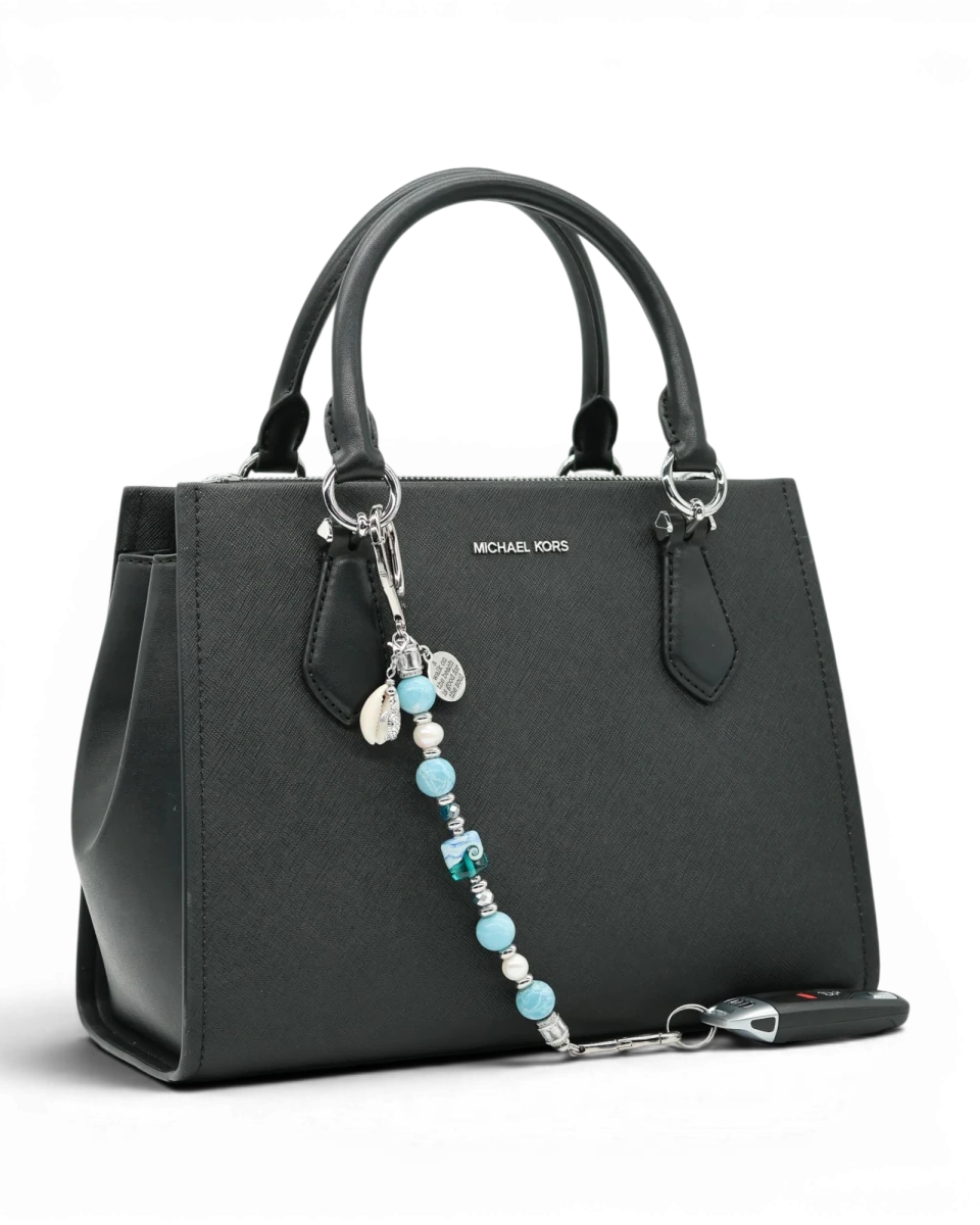 LD Keyfinder Beachy Dreams keychain with teal, blue, and white beads, freshwater pearls, and charms on a black handbag.