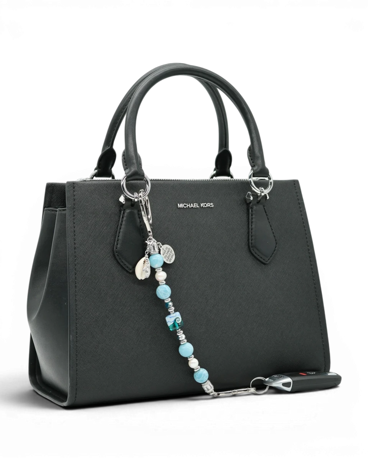 LD Keyfinder Beachy Dreams keychain with teal, blue, and white beads, freshwater pearls, and charms on a black handbag.