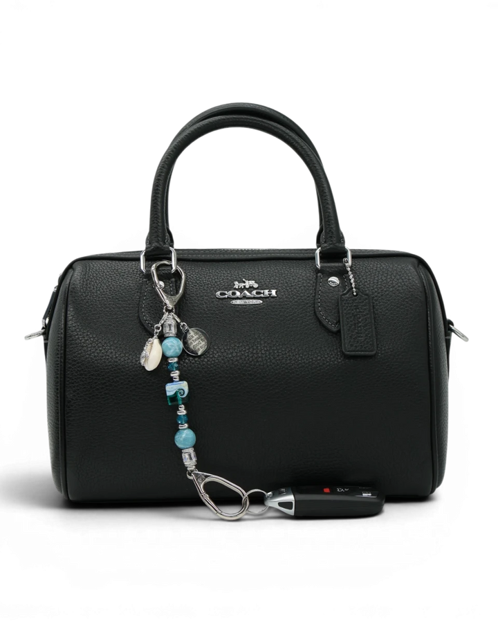 LD Keyfinder Petite Beachy Dreams charm with blue and teal beads, a turtle charm, and a shell charm attached to a black handbag.