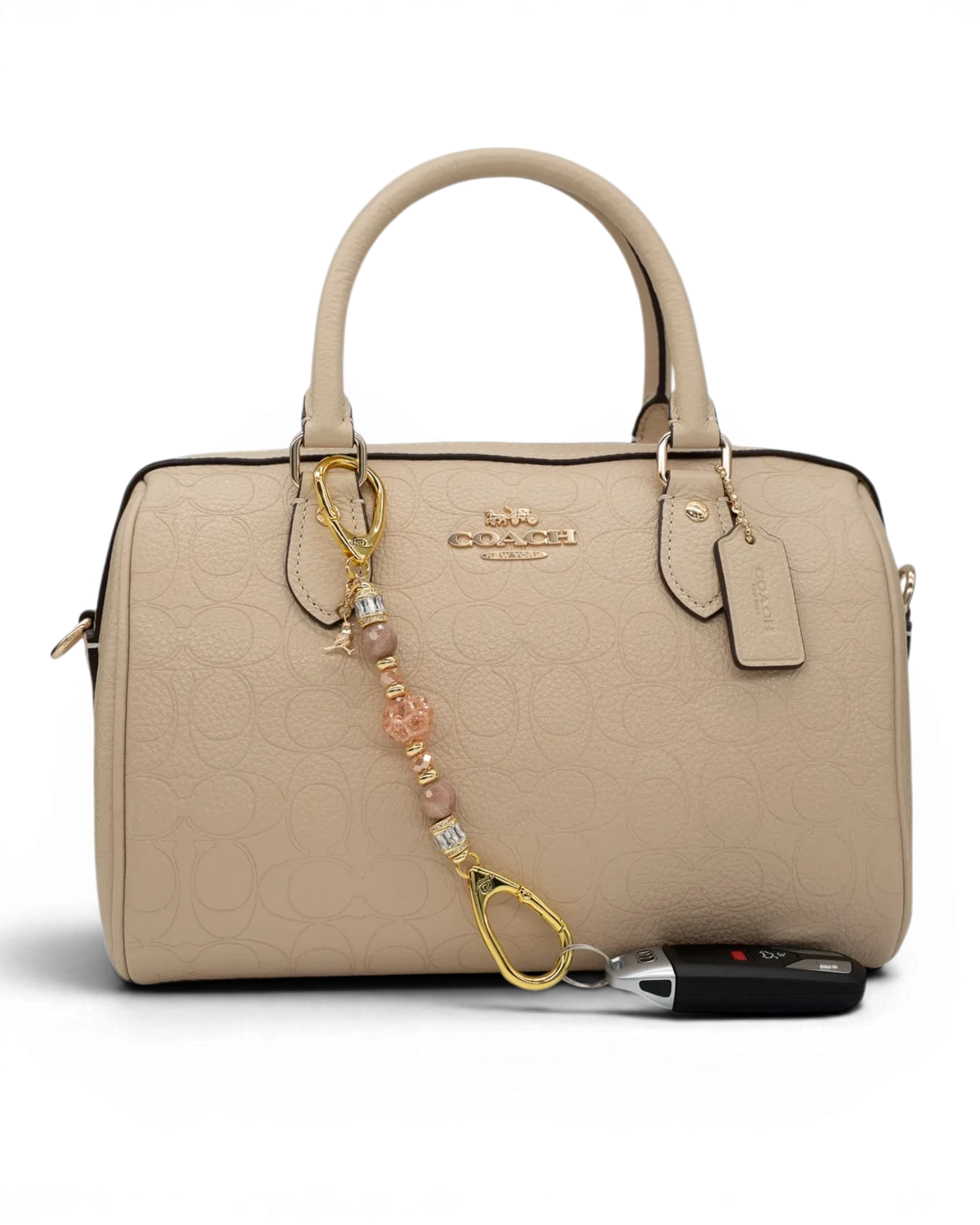 LD Keyfinder Petite Birdsong Bliss beaded accessory with sunstone and peach glass attached to a beige leather handbag.