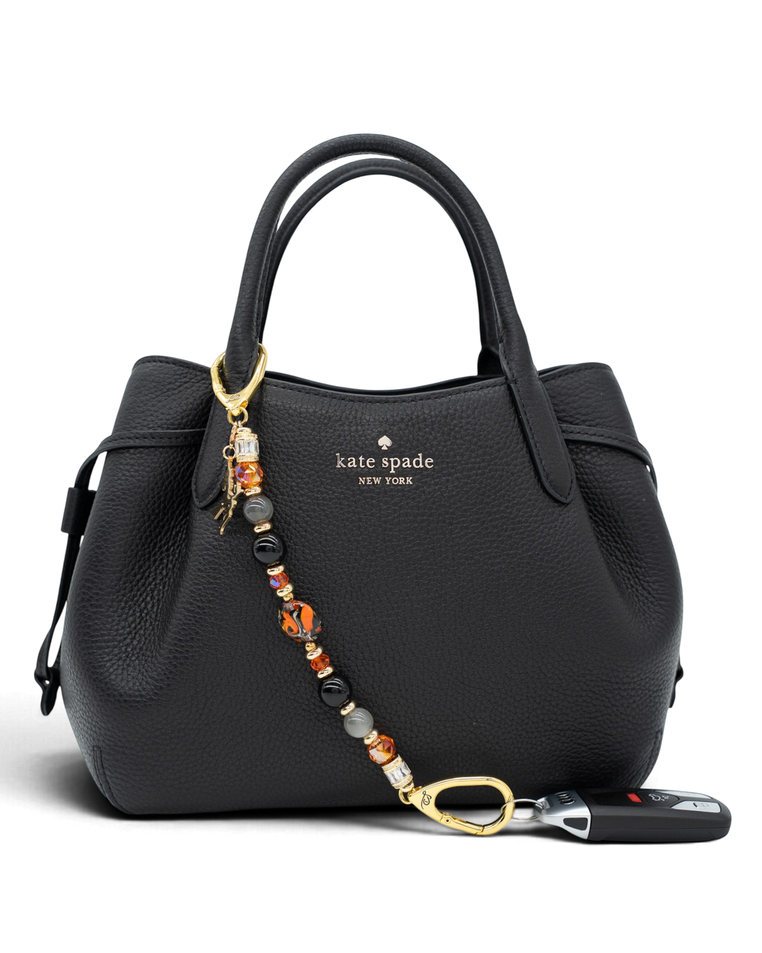 LD Keyfinder Bewitched Halloween accessory with obsidian, moonstone, and orange glass beads attached to a black handbag.