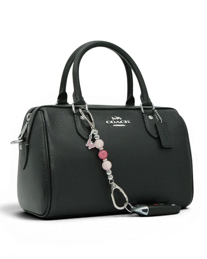 LD Keyfinder Blush Butterfly Mini charm with rose quartz beads and pink rhinestone butterfly on a black handbag.