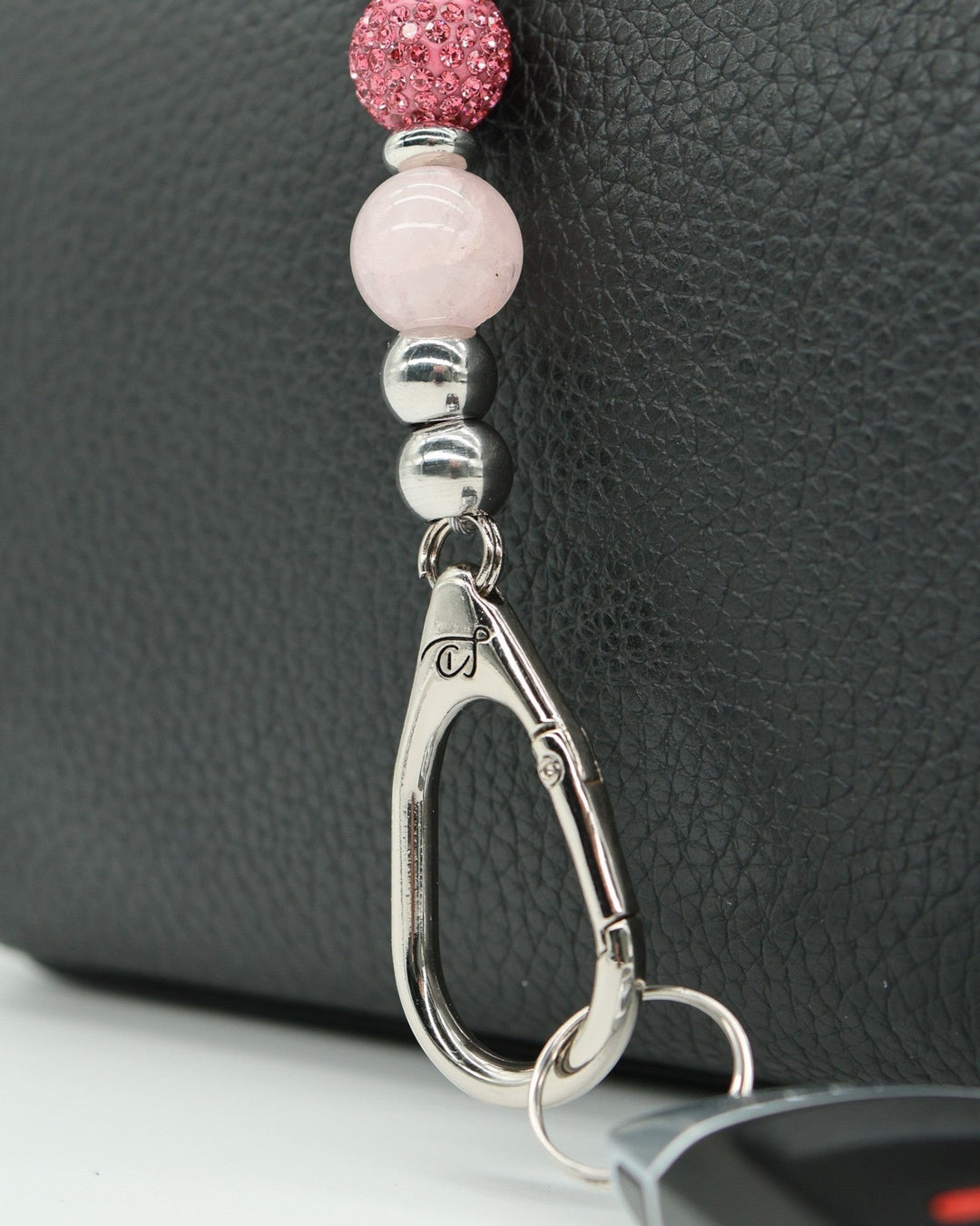 LD Keyfinder Blush Butterfly Mini keychain with rose quartz, pink crystal bead, and butterfly charm on a black textured background.