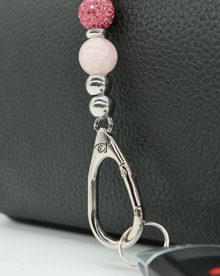 LD Keyfinder Blush Butterfly Mini keychain with rose quartz, pink crystal bead, and butterfly charm on a black textured background.