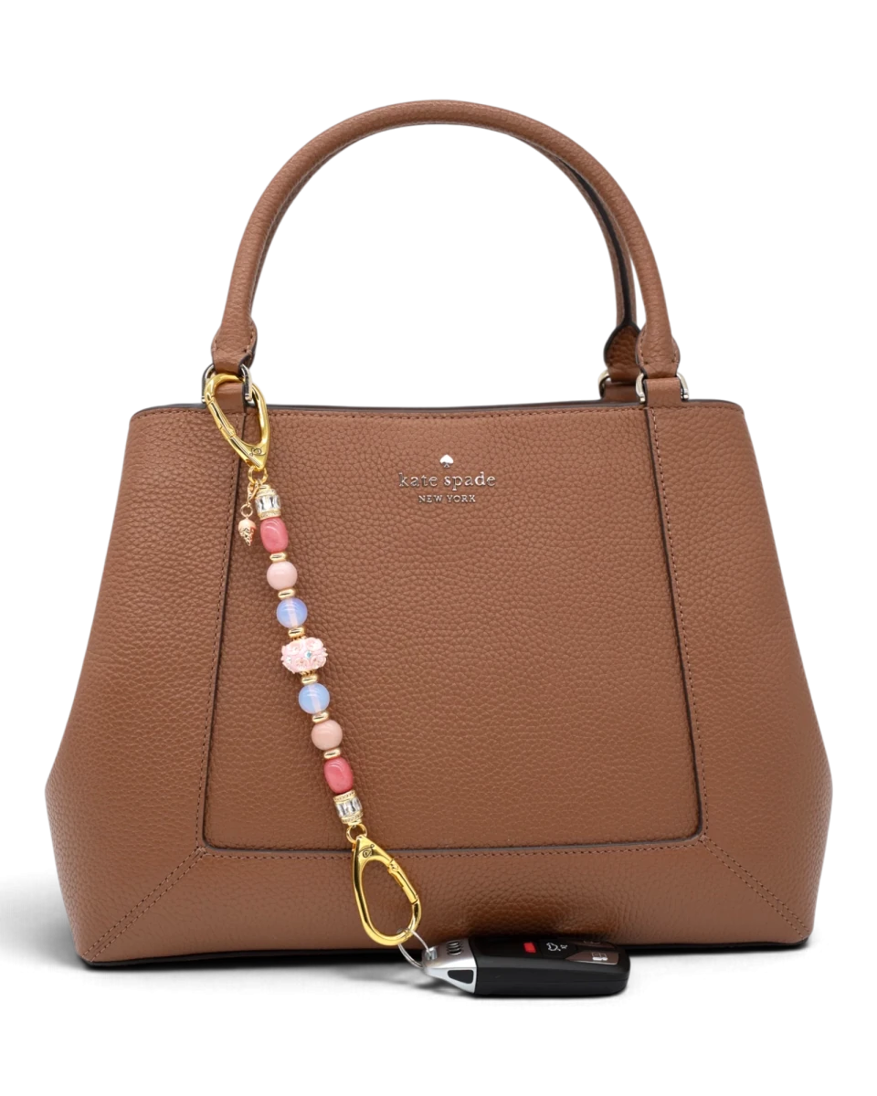 LD Keyfinder Blush Sorbetto beaded accessory with pink gemstones and ice cream charm attached to a brown leather bag
