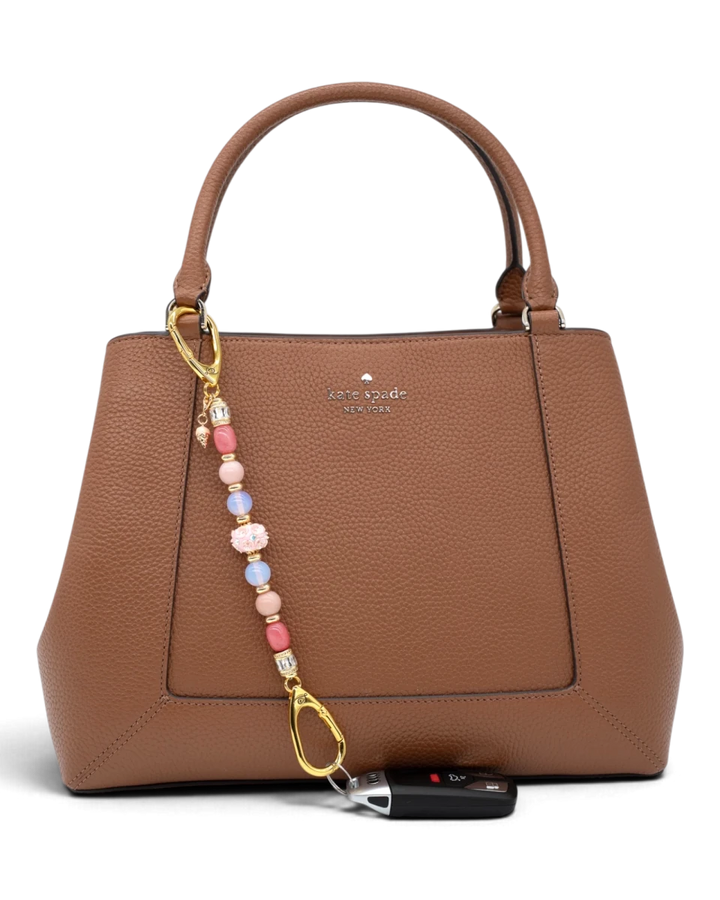 LD Keyfinder Blush Sorbetto beaded accessory with pink gemstones and ice cream charm attached to a brown leather bag