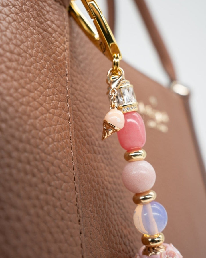 LD Keyfinder Blush Sorbetto beaded charm with pink gemstones, iridescent beads, and a gold ice cream cone on a handbag.