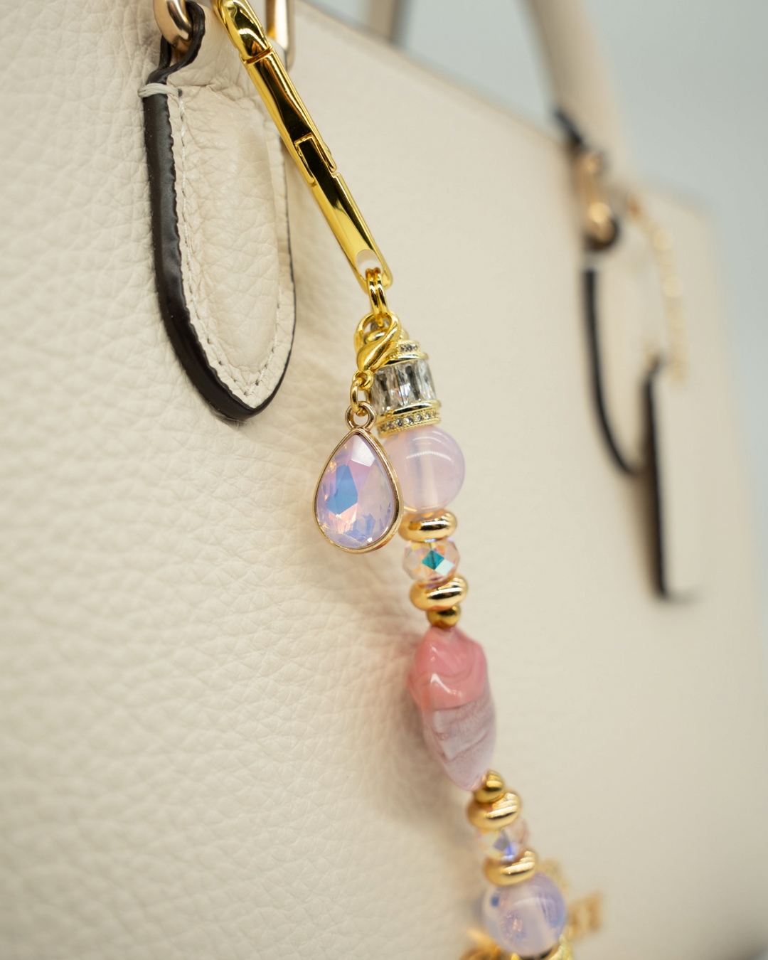 LD Keyfinder Blushing Opaline Petite featuring pink opalite beads, artisan glass, and gold-plated accents on a handbag.