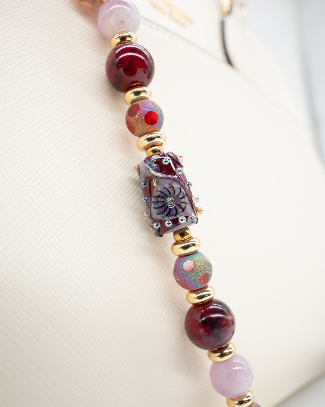 LD Keyfinder Bordeaux Bloom beaded accessory with burgundy agate, lavender kunzite, artisan glass, and gold accents.