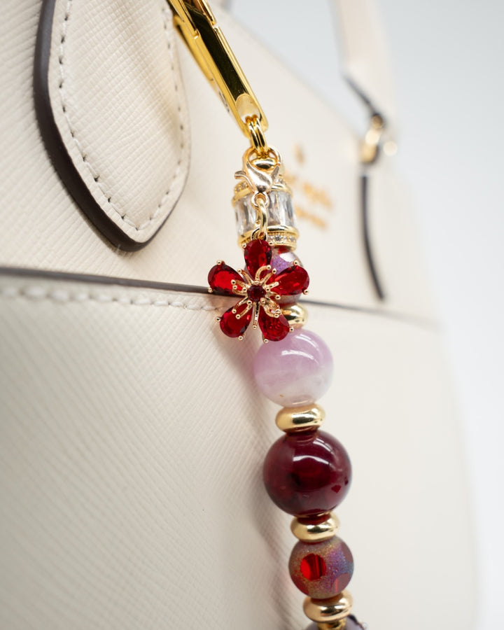 LD Keyfinder Bordeaux Bloom artisan beaded bag charm with burgundy agate, lavender kunzite, and a red flower charm.