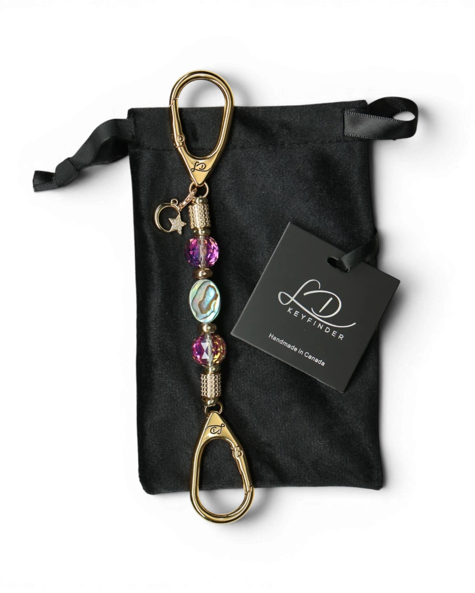 LD Keyfinder Borealis Glow-Mini keychain with abalone shell, crystal beads, gold hardware, and star charm on black velvet pouch.