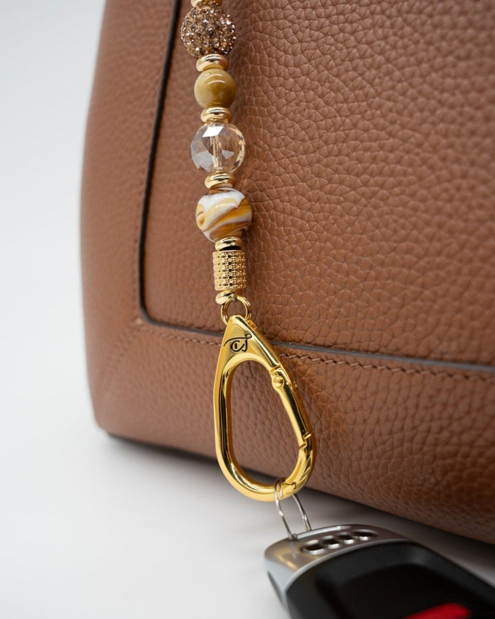 LD Keyfinder Caramel Latte beaded keychain with tiger eye, lampwork glass, and gold-plated coffee cup charm on a bag