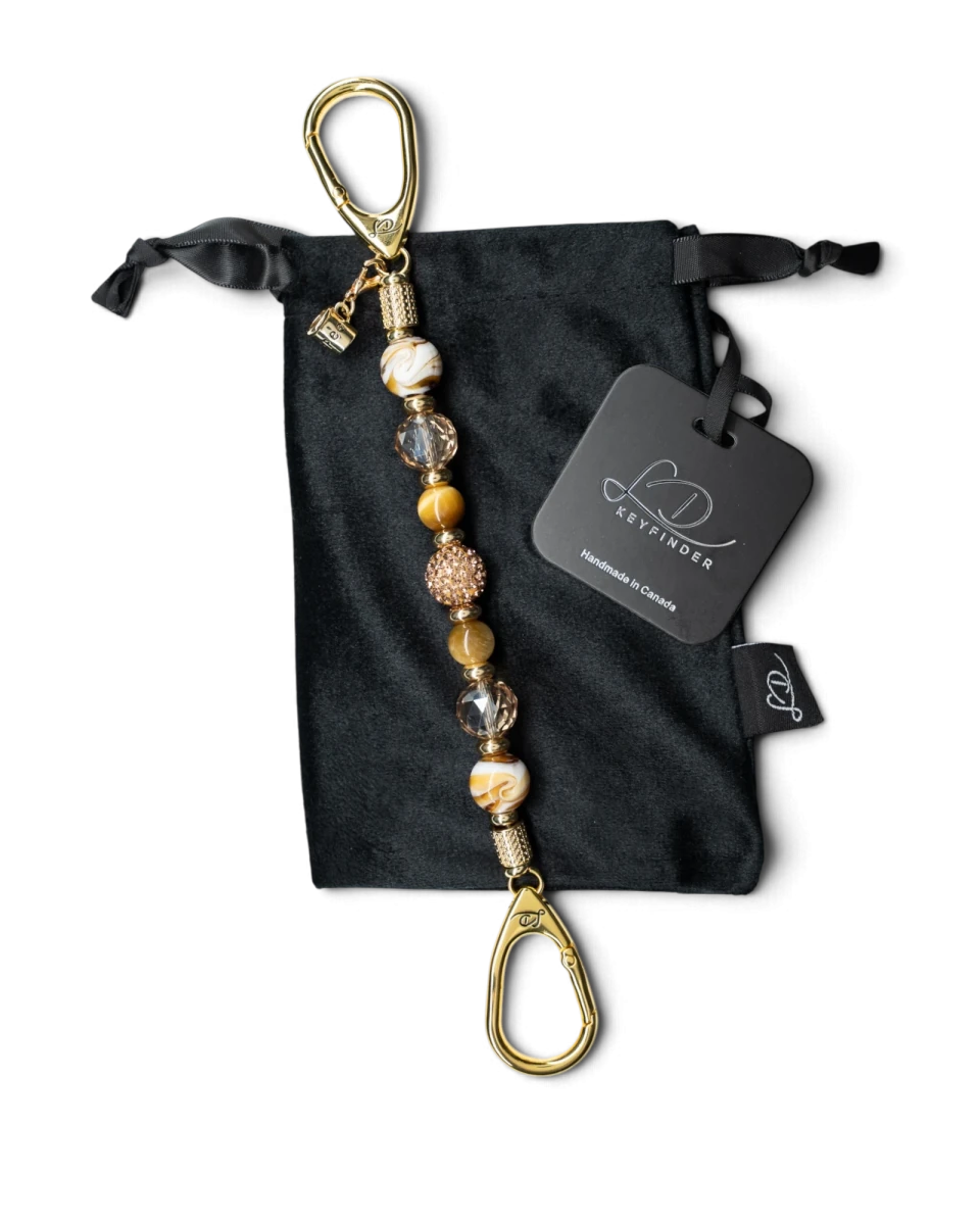 LD Keyfinder Caramel Latte beaded keychain with tiger eye, lampwork glass, and a gold coffee cup charm on velvet bag
