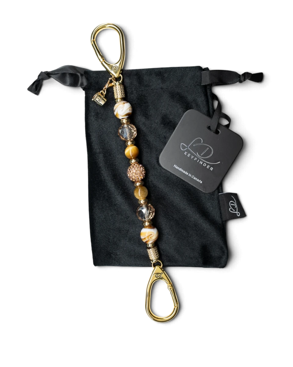 LD Keyfinder Caramel Latte beaded keychain with tiger eye, lampwork glass, and a gold coffee cup charm on velvet bag