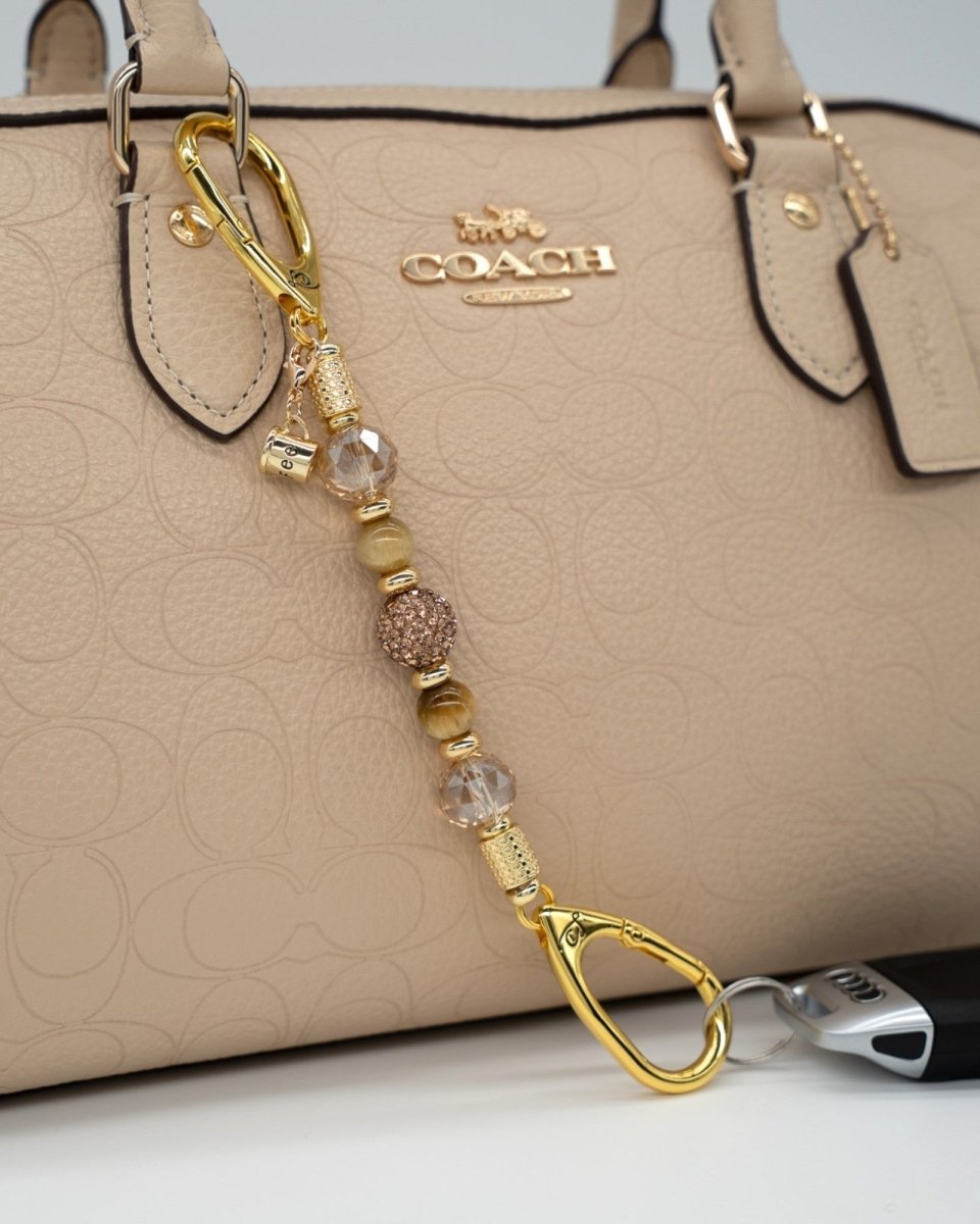 LD Keyfinder Caramel Latte-Mini featuring tiger eye gemstones, golden crystals, and a coffee cup charm on a handbag.