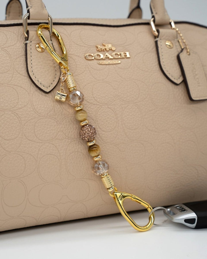 LD Keyfinder Caramel Latte-Mini featuring tiger eye gemstones, golden crystals, and a coffee cup charm on a handbag.