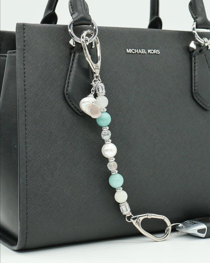 LD Keyfinder Caribbean Pearl beaded accessory with moonstone, aqua jade, and shell pearl charms attached to a black bag.
