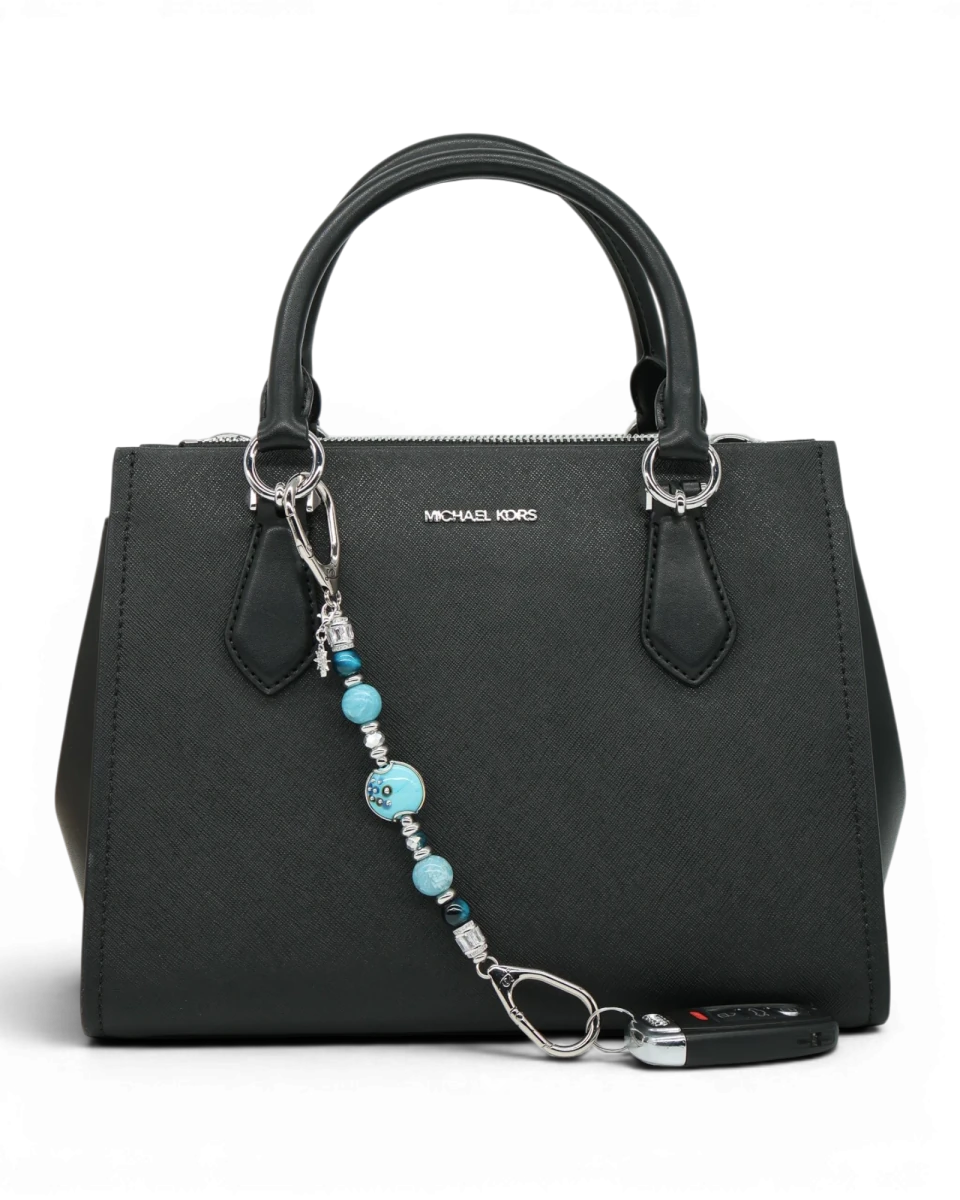 LD Keyfinder Celestial Tide keychain with turquoise, aqua, silver beads, and star charm attached to a black handbag.