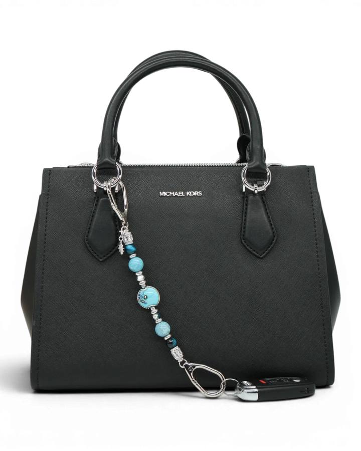LD Keyfinder Celestial Tide keychain with turquoise, aqua, silver beads, and star charm attached to a black handbag.
