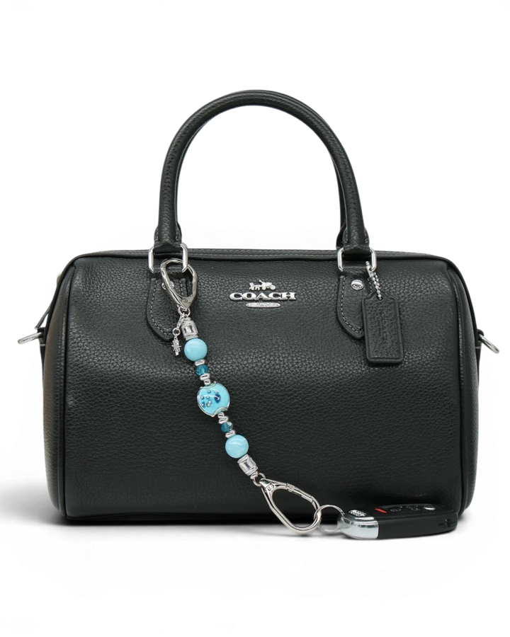 LD Keyfinder Petite Celestial Tide keychain with turquoise, aqua, and silver beads and a star charm attached to a black handbag.