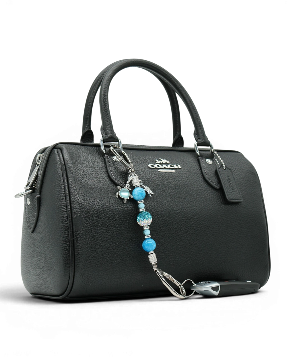 LD Keyfinder Coastal Tide Mini keychain with blue gemstone beads, turtle and starfish charms attached to a black handbag.
