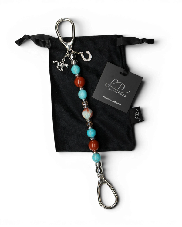 LD Keyfinder Cowgirl Dreams beaded keychain with jasper, turquoise, and horse charms on a black velvet pouch.