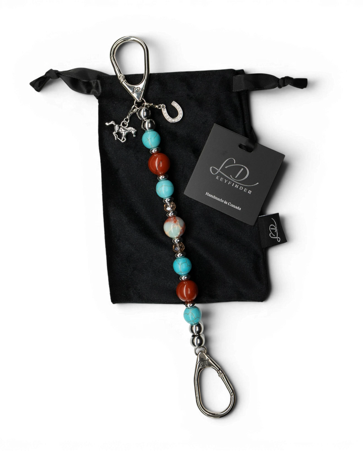 LD Keyfinder Cowgirl Dreams beaded keychain with jasper, turquoise, and horse charms on a black velvet pouch.