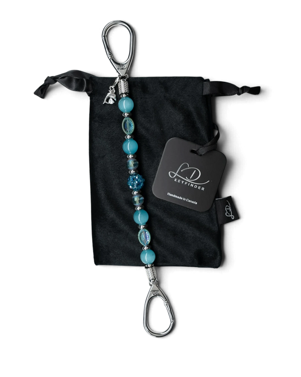 LD Keyfinder Dolphin Dream beaded key finder with aqua glass beads and a rhinestone dolphin charm on a velvet pouch.