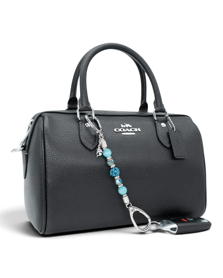 LD Keyfinder Dolphin Dream Mini beaded keychain with aqua glass beads and a rhinestone dolphin charm on a black bag.