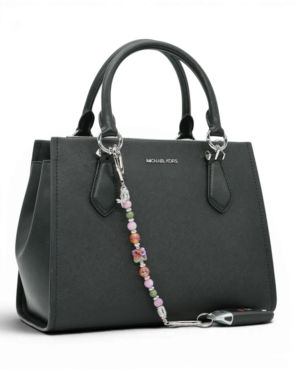 LD Keyfinder Dragonfly Magic charm with purple lepidolite, green jade, and orange glass beads on a black handbag.