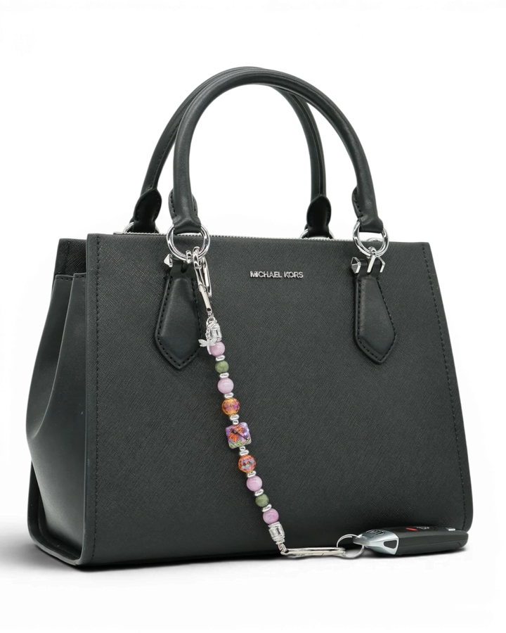 LD Keyfinder Dragonfly Magic charm with purple lepidolite, green jade, and orange glass beads on a black handbag.