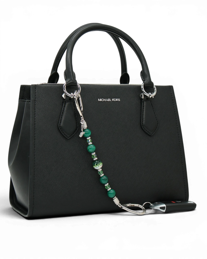 LD Keyfinder Emerald Links beaded keychain with green agate, Austrian crystals, and a golf bag charm on a black purse.