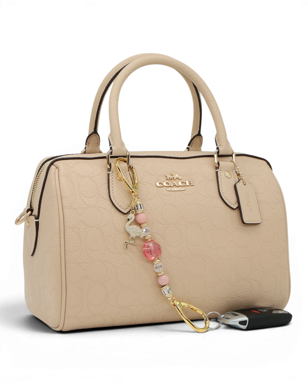 LD Keyfinder Petite Flamingo Fantasy accessory with pink opal beads and gold flamingo charm attached to a beige bag.