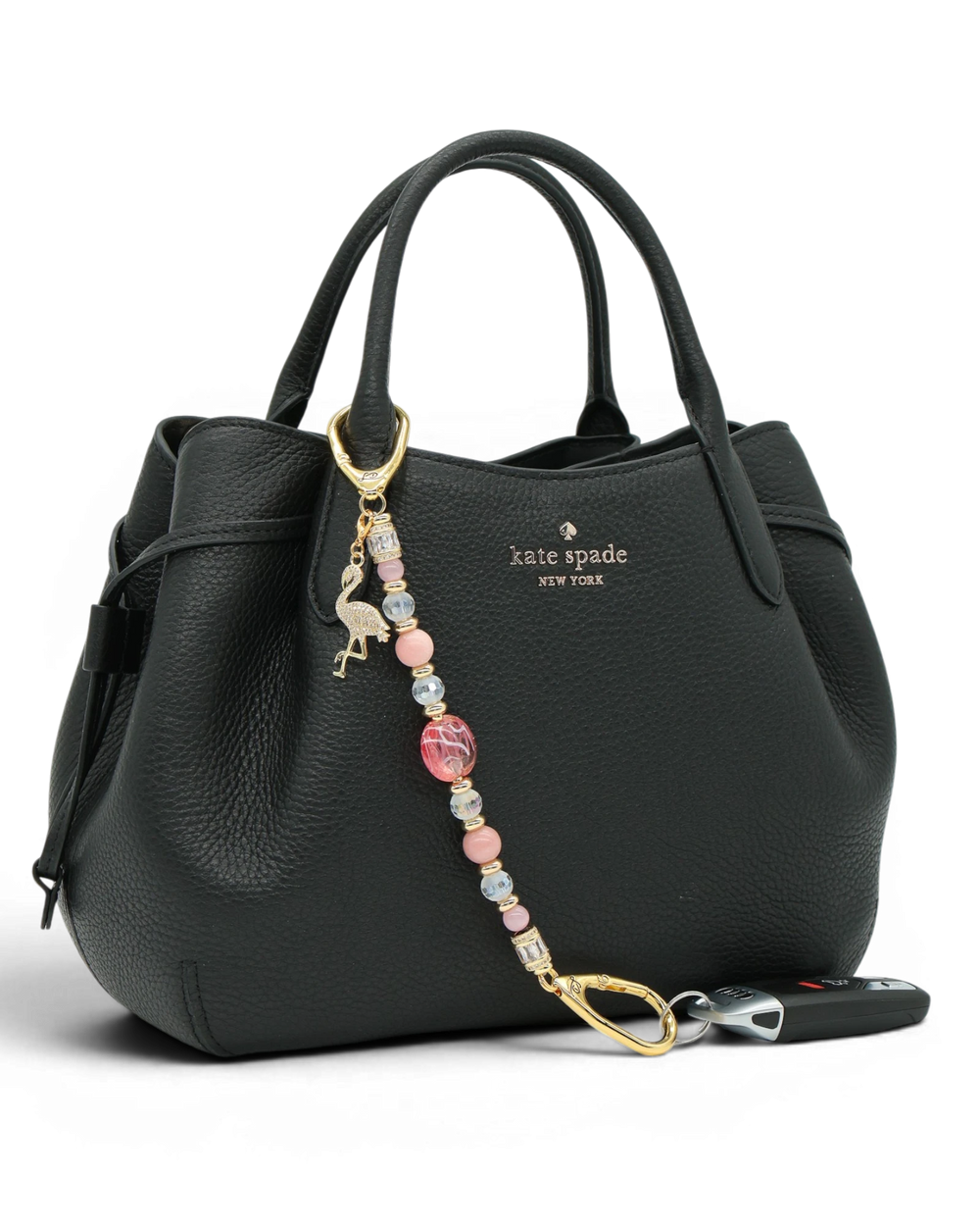 LD Keyfinder Flamingo Fantasy beaded keychain with pink opal, cat's eye, and gold flamingo charm on a black handbag.