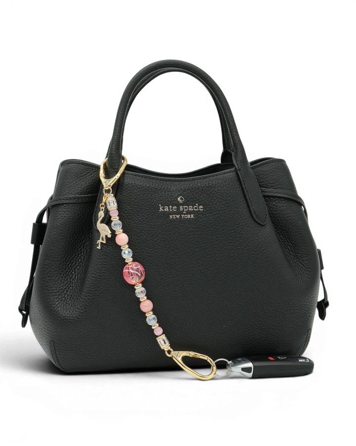 LD Keyfinder Flamingo Fantasy beaded accessory with pink opal and glass beads attached to a black leather handbag.