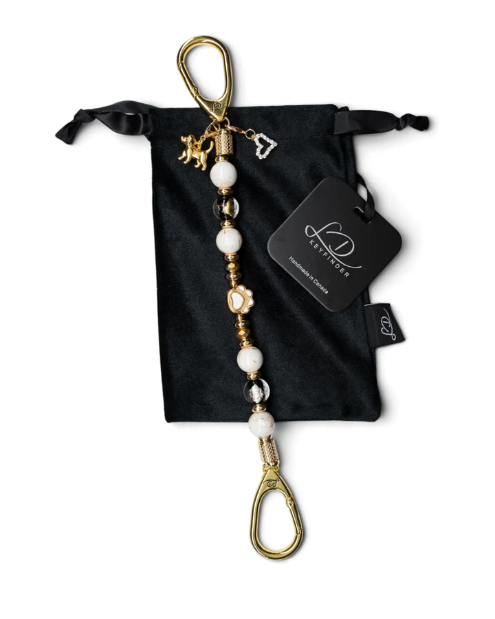 LD Keyfinder Furever Love beaded keychain with white seashell beads, gold paw charm, and heart pendant in velvet bag.